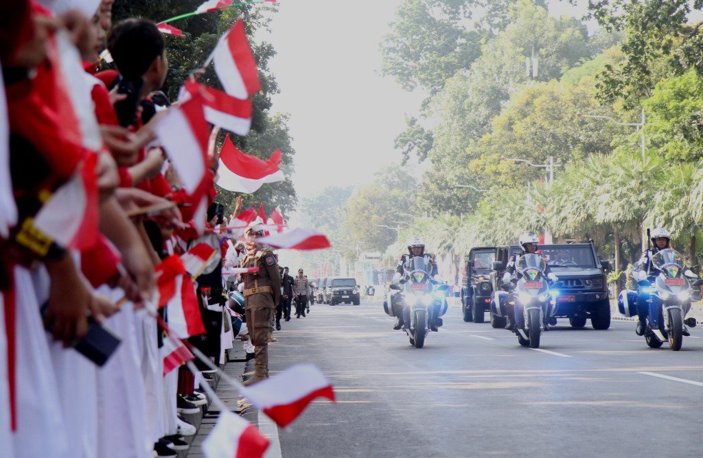 Massarakat memadati jalan menyambut bendera Merah Putih menuju Istana Nusantara di IKN